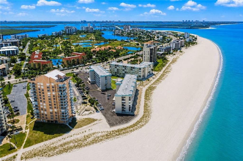 Coastal landscape featuring a wide sandy beach bordering clear blue waters