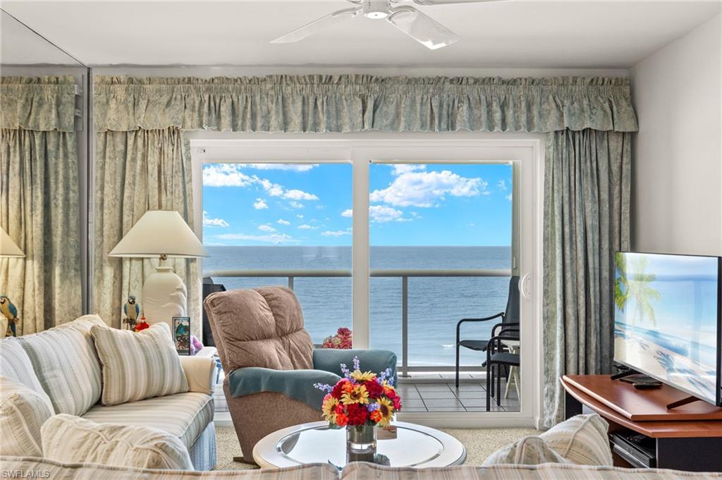Sliding glass doors opening to a balcony with glass railings overlooking the ocean