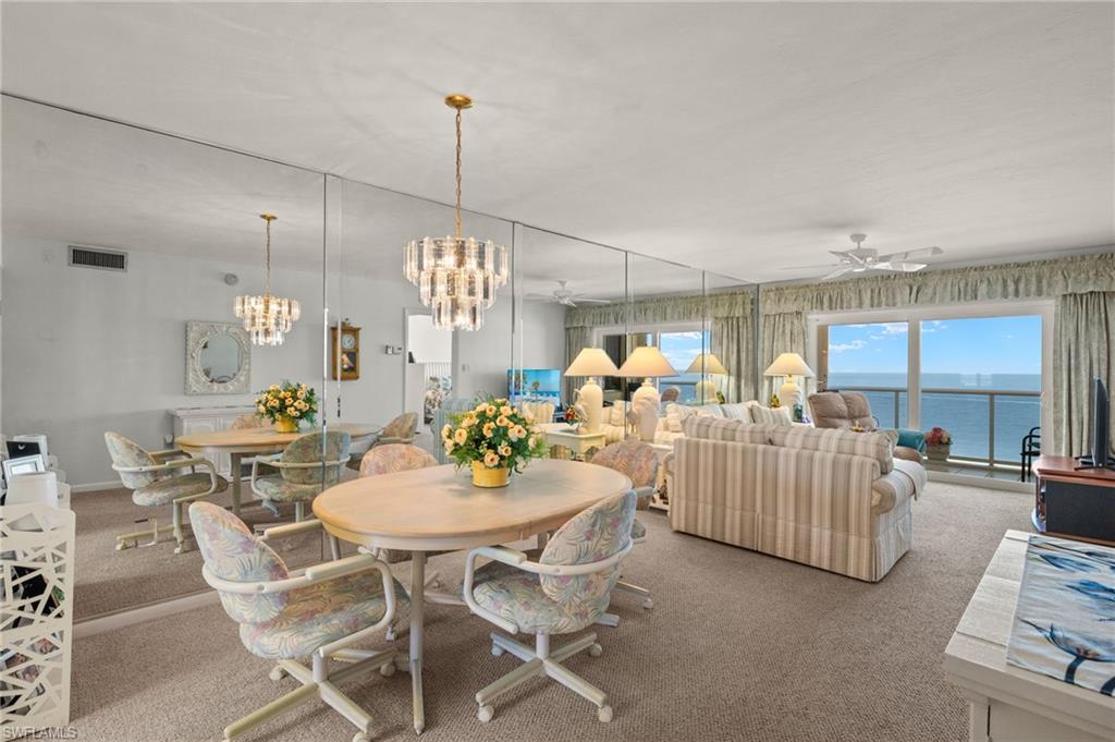 Open-concept living area with expansive floor-to-ceiling windows overlooking a water panorama