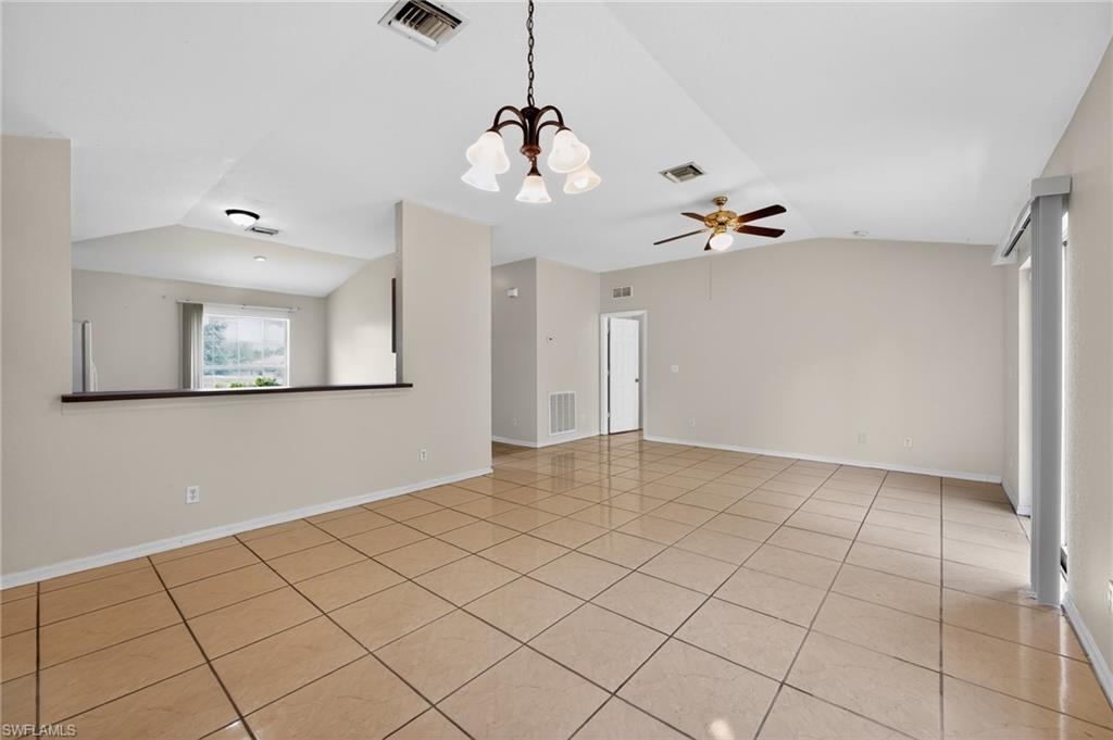 Spacious living area featuring neutral-toned walls and large square floor tiles
