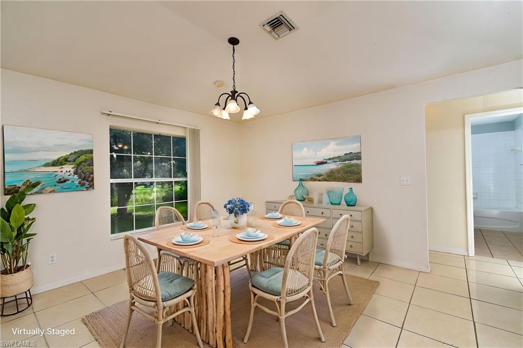 Dining space featuring tile flooring, a multi-light ceiling fixture, and a window with exterior views