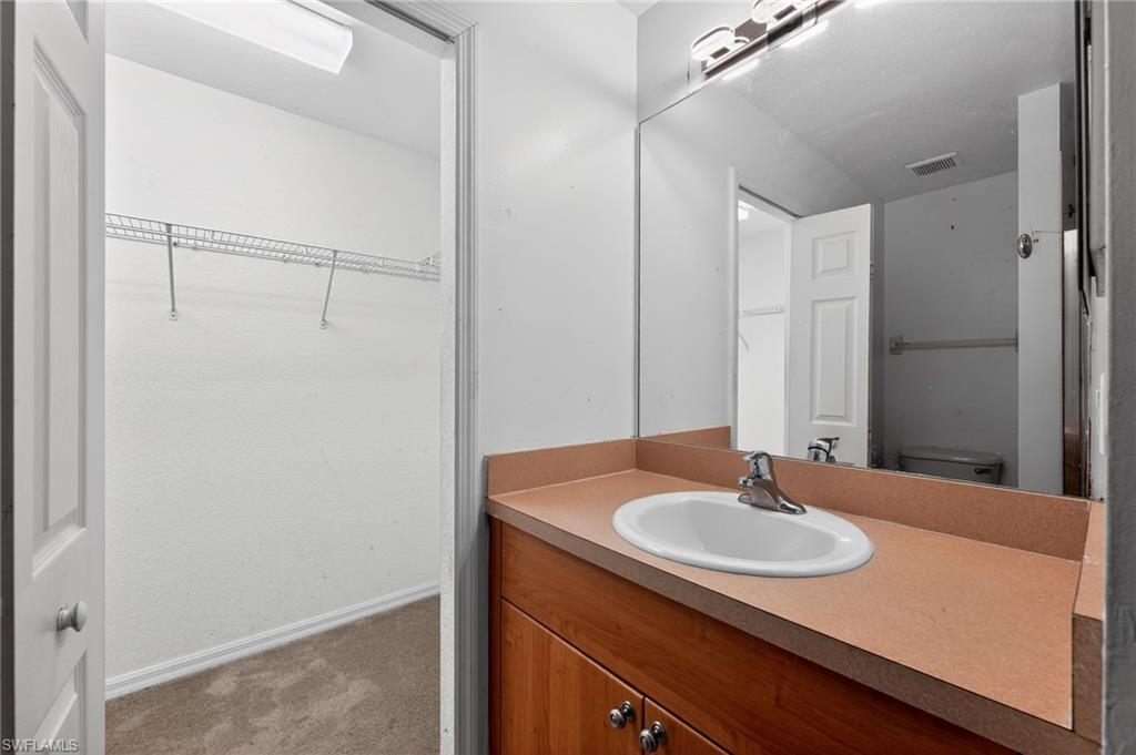Bathroom vanity with an integrated sink, wood-finish cabinetry, and a chrome faucet