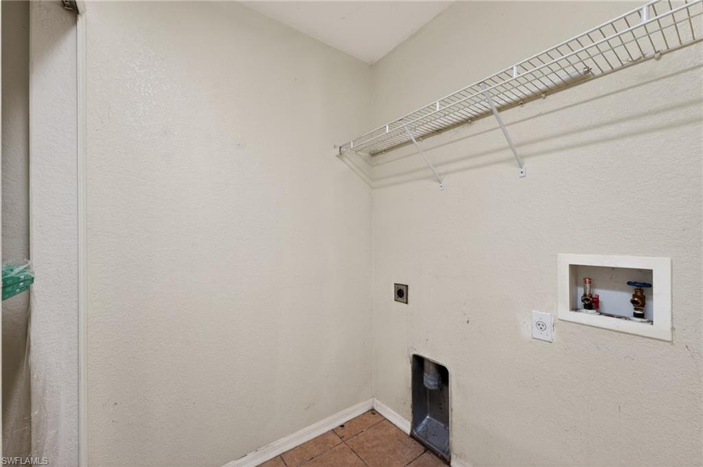 Utility room featuring a wire shelving unit, appliance hookups, and a neutral wall finish