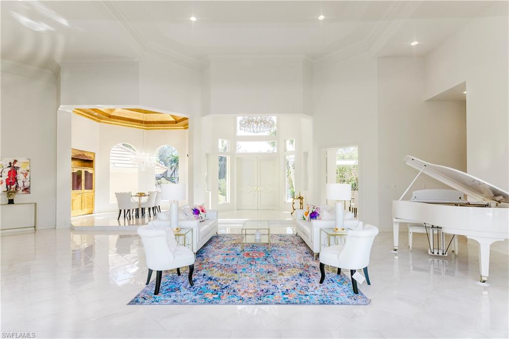 Living room with plenty of natural light, crown molding, and a high ceiling