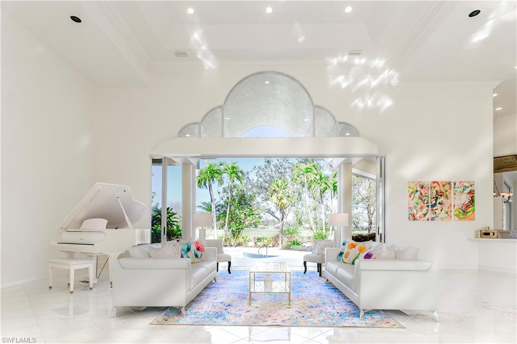 Living room with a high ceiling, a tray ceiling, and ornamental molding