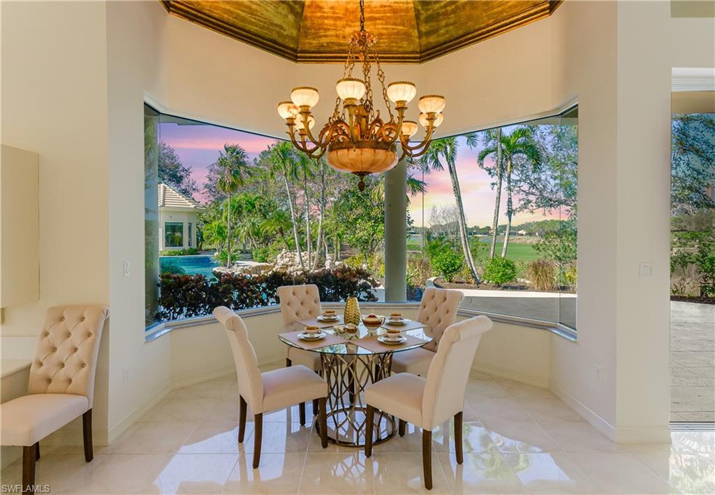 Tiled dining area featuring crown molding and a notable chandelier