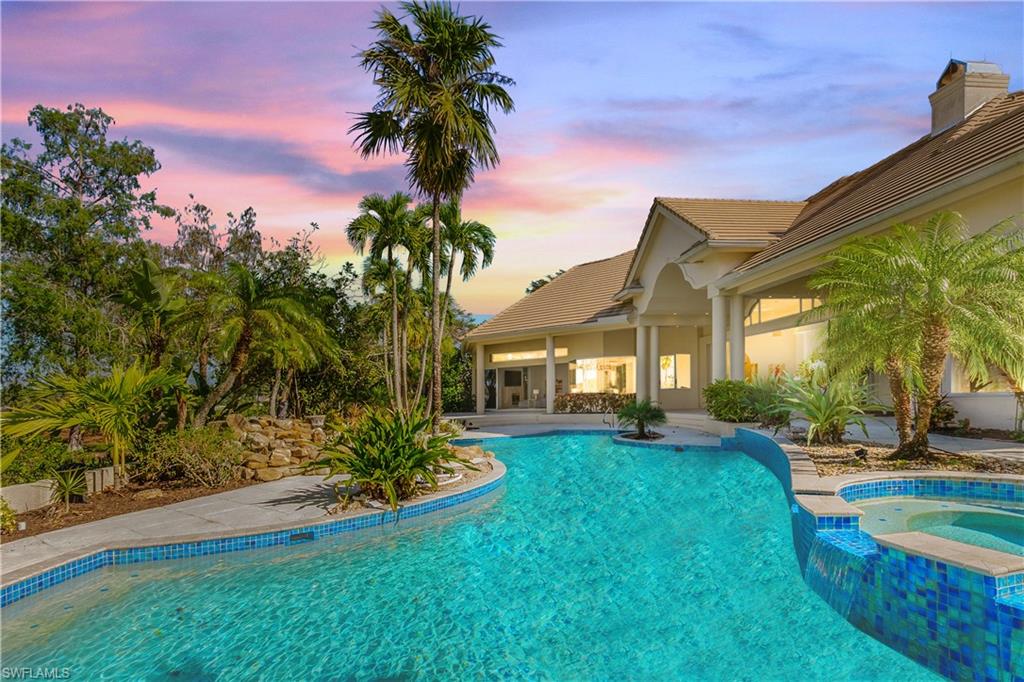 Pool at dusk with an in ground hot tub