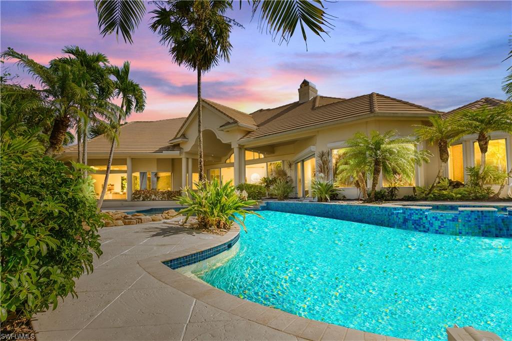 Pool at dusk featuring a patio