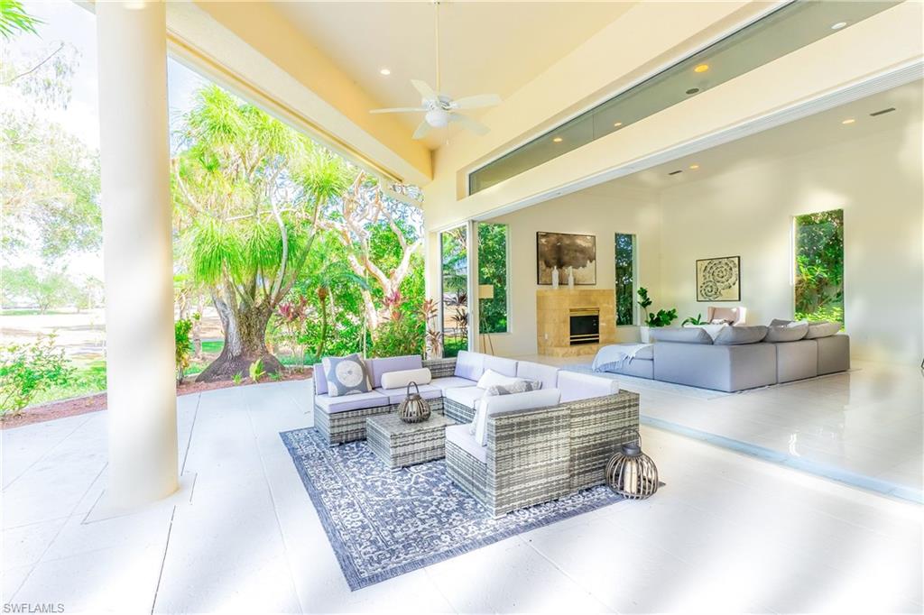 View of patio with ceiling fan and an outdoor living space with a fireplace