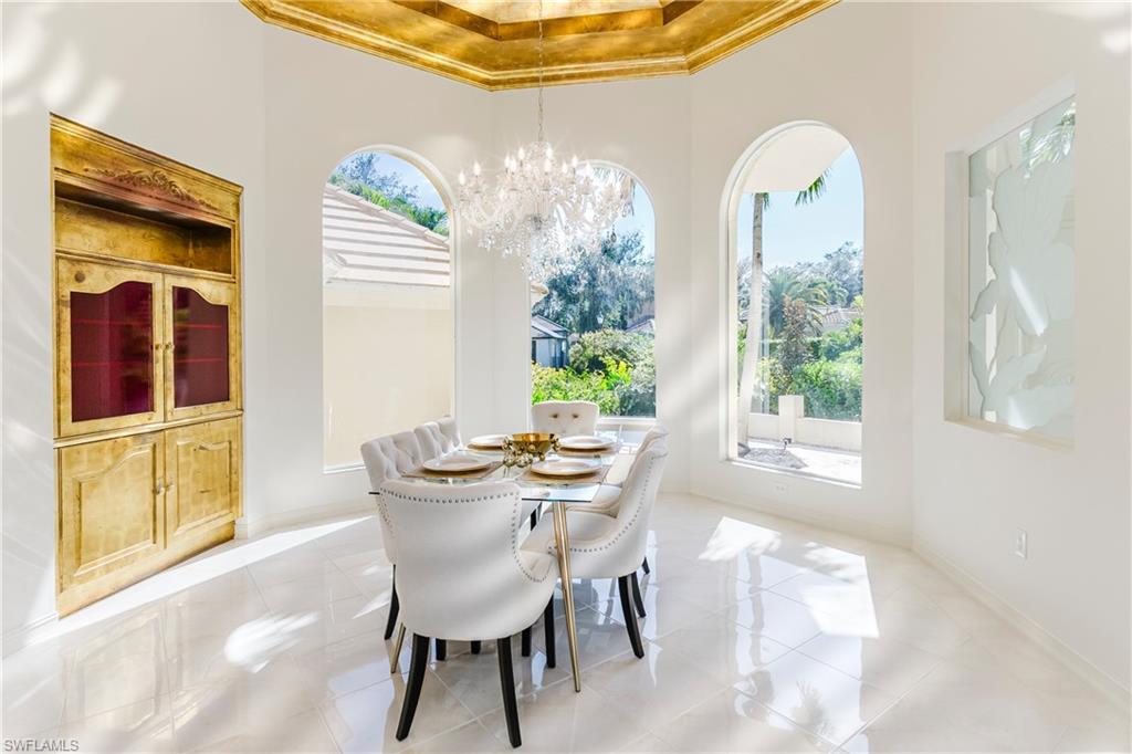 Dining space with a high ceiling, ornamental molding, and a chandelier