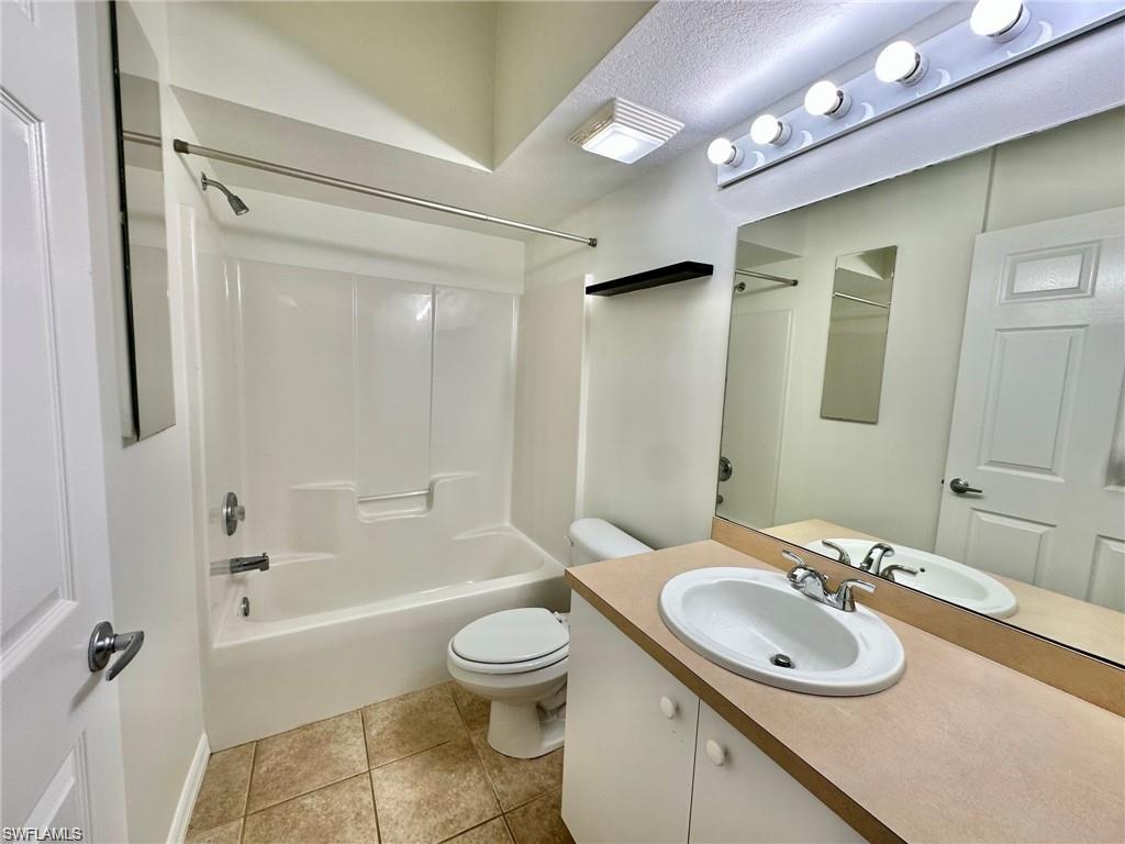 Full bathroom featuring a single vanity with an oval sink, a wall-mounted mirror, and a combination tub and shower