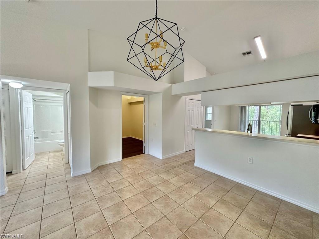Well-appointed kitchen featuring white cabinetry, light-toned countertops, and tile flooring