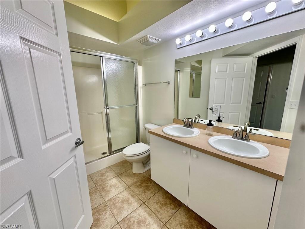 Bathroom featuring a dual vanity with undermount sinks, a full-width mirror, and a Hollywood-style light fixture