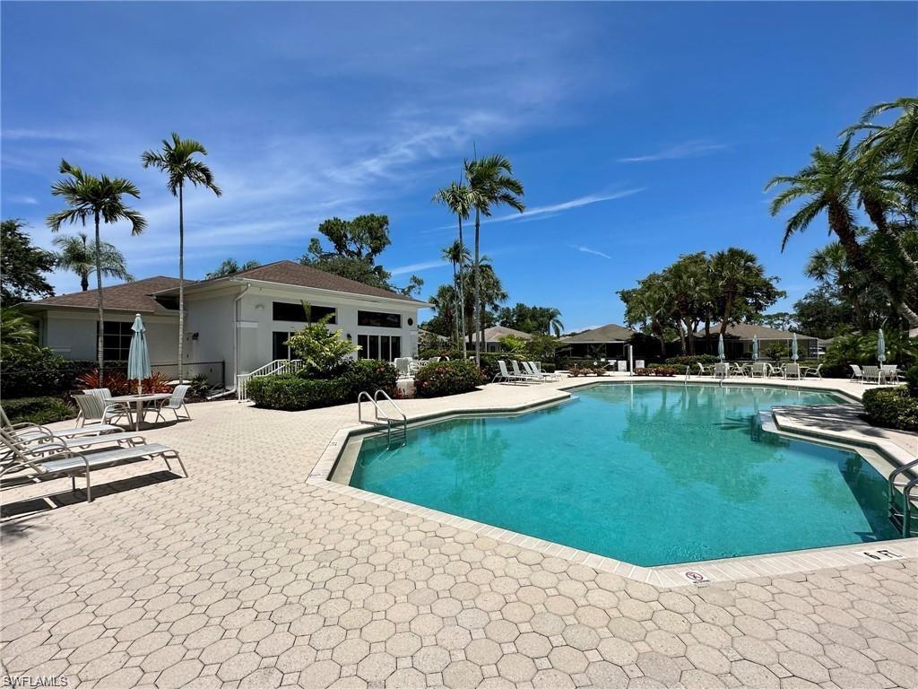 Expansive outdoor pool area featuring a freeform pool with integrated steps, surrounded by patterned paver decking