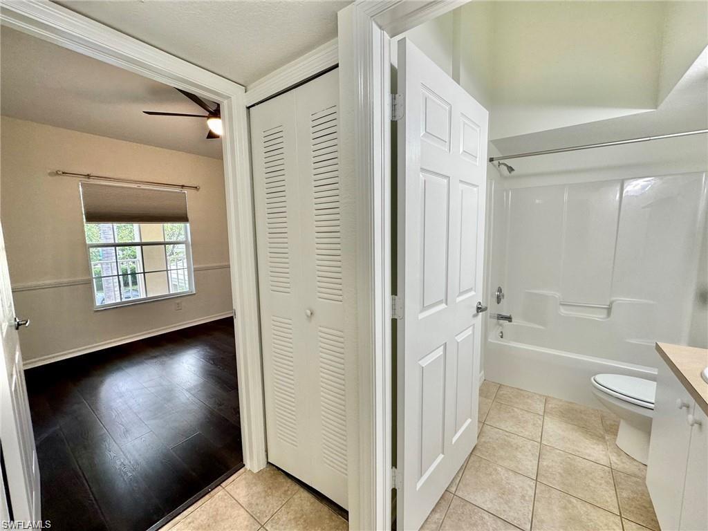 Bathroom featuring a white tub/shower combination, ceramic tile flooring, and a white vanity with a light-colored countertop
