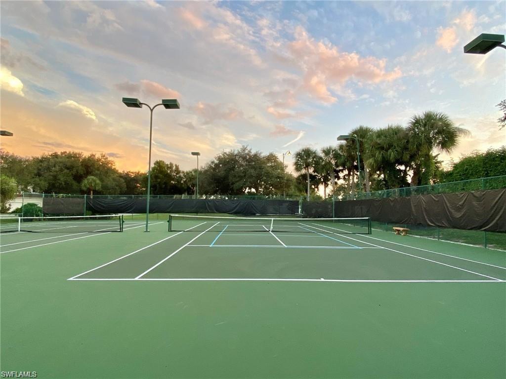 Green hard-surface tennis courts featuring white and blue court lines