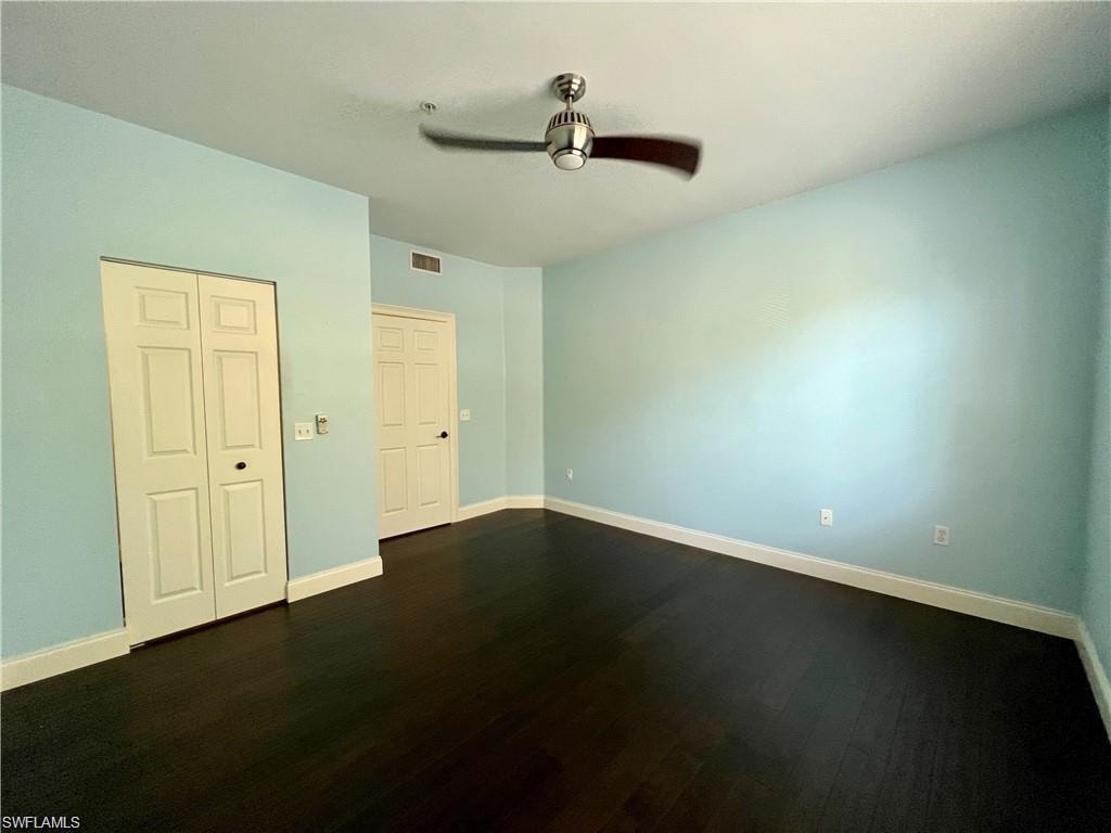 Unfurnished bedroom featuring dark wood-style flooring,