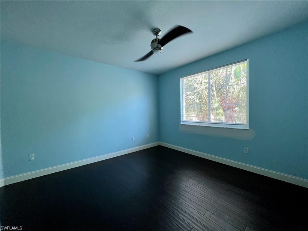 Unfurnished bedroom featuring dark wood-type flooring and ceiling fan