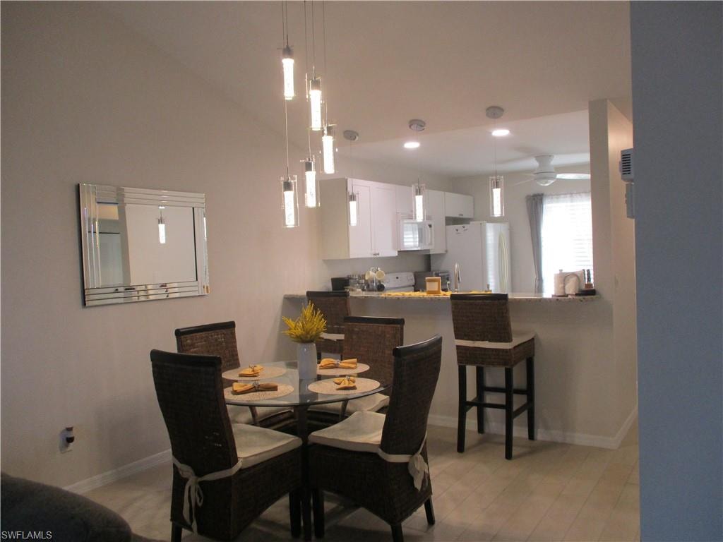 Dining room featuring baseboards, ceiling fan, recessed lighting, lofted ceiling, and light wood-type flooring.