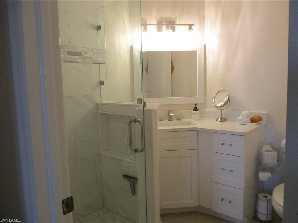 Full bath featuring toilet, vanity, and a stall shower