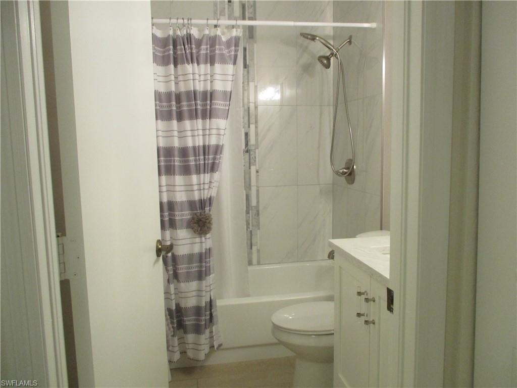 Full bathroom with toilet, vanity, and shower / tub combo