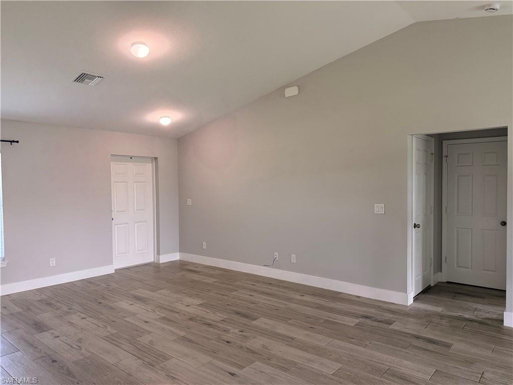 Vaulted ceiling with recessed lighting, complemented by light grey walls and white baseboards