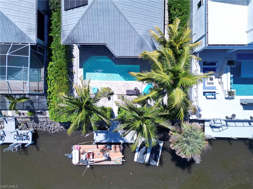 Waterfront property featuring a private boat dock, a rectangular swimming pool, and a spacious patio area