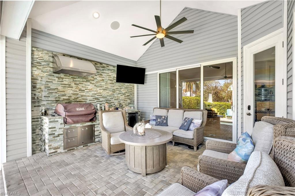 Covered patio featuring an outdoor kitchen with stone veneer and stainless steel cabinetry