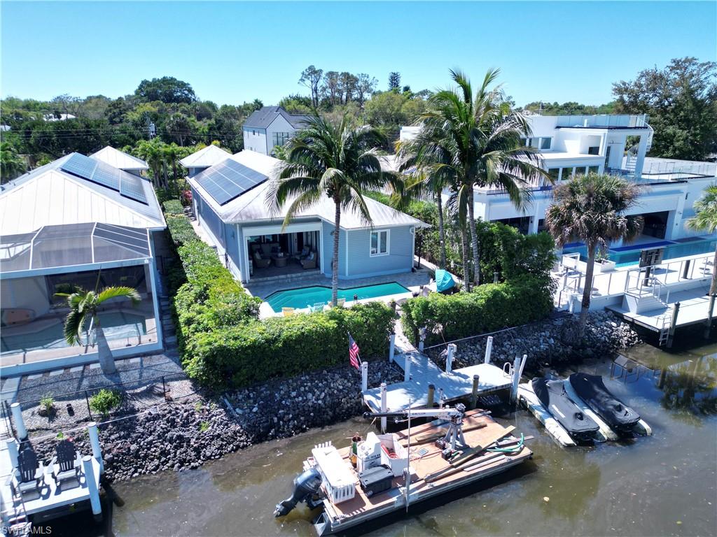 Waterfront property featuring a private boat dock, a swimming pool, and solar panels