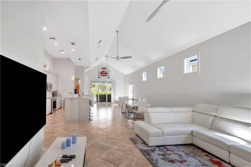 Open-concept living space featuring vaulted ceilings, recessed lighting, and large format tile flooring