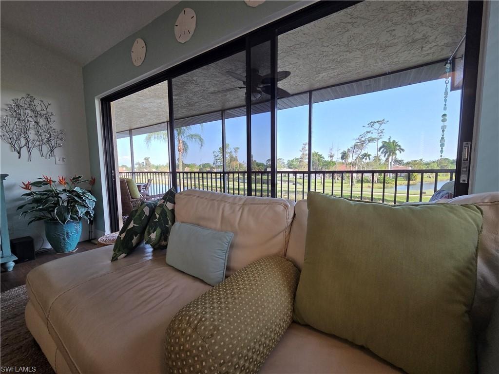 Living room view of the lake through the sliding glass doors that open to a screened lanai, offering expansive views of a body of water and distant trees