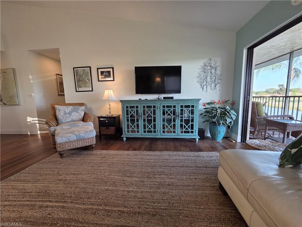 Spacious interior featuring hardwood floors, high ceilings, and direct access to a screened-in lanai with views of a body of water
