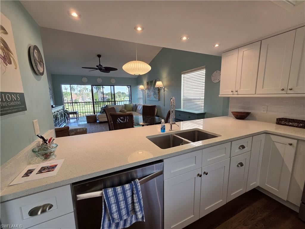 The kitchen features white cabinetry, light-colored countertops, a stainless steel sink with a goose-neck faucet, and a dishwasher