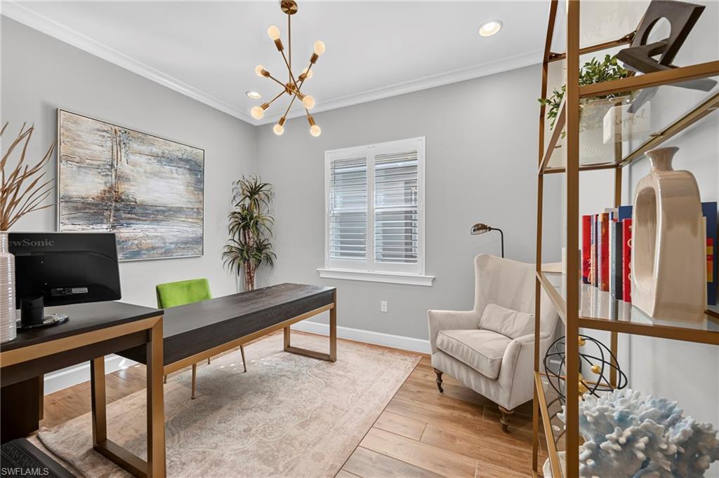 Spacious room featuring wood-finish flooring, a modern sputnik chandelier, crown molding, and plantation shutters
