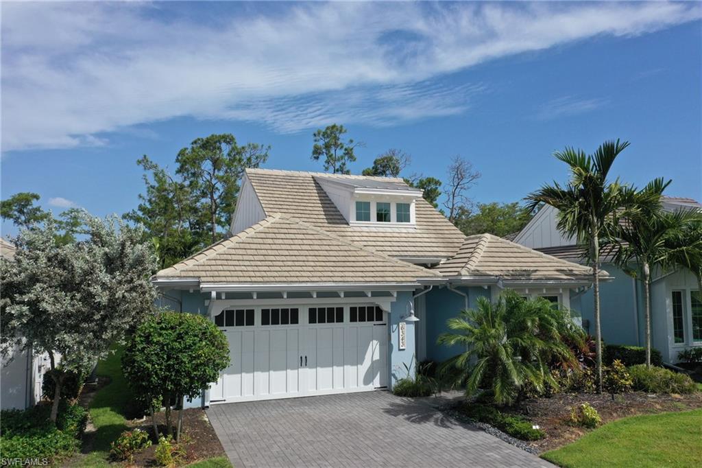 Coastal-inspired exterior featuring a light blue facade and a multi-gabled tile roof