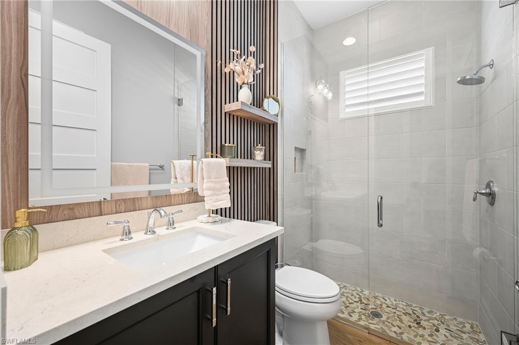 Modern bathroom featuring a dark wood vanity with a white countertop and undermount sink