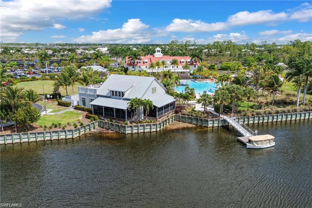 Waterfront property featuring a screened-in porch, metal roof, and direct water access with a private dock