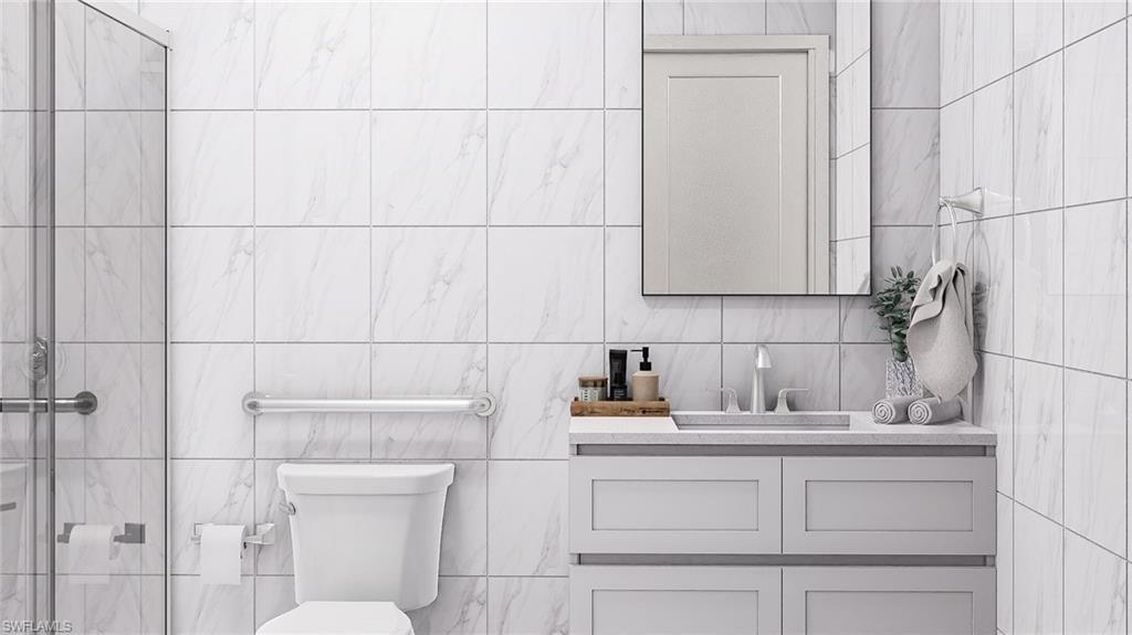 Full bath featuring vanity and tile walls