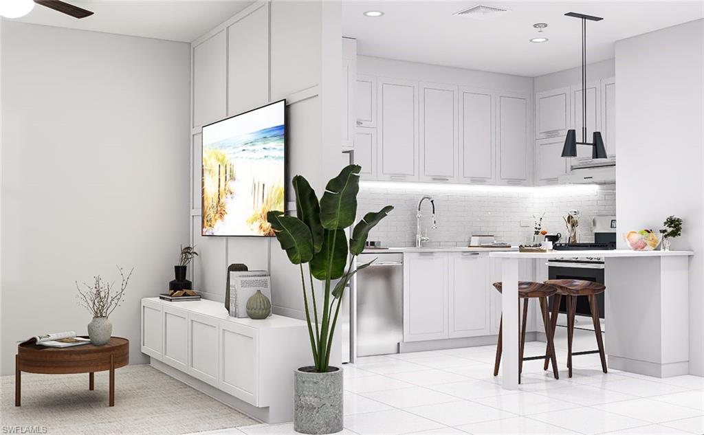 Kitchen featuring white cabinetry, decorative backsplash, a breakfast bar area, light tile patterned floors, and appliances with stainless steel finishes