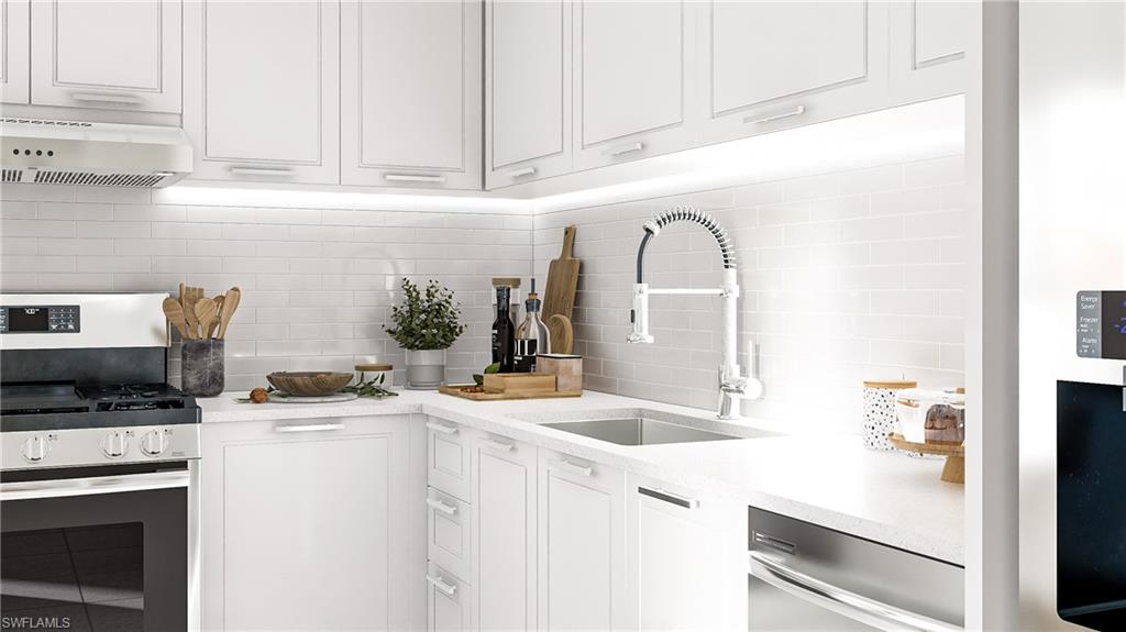 Kitchen featuring appliances with stainless steel finishes, white cabinets, backsplash, exhaust hood, and light stone countertops