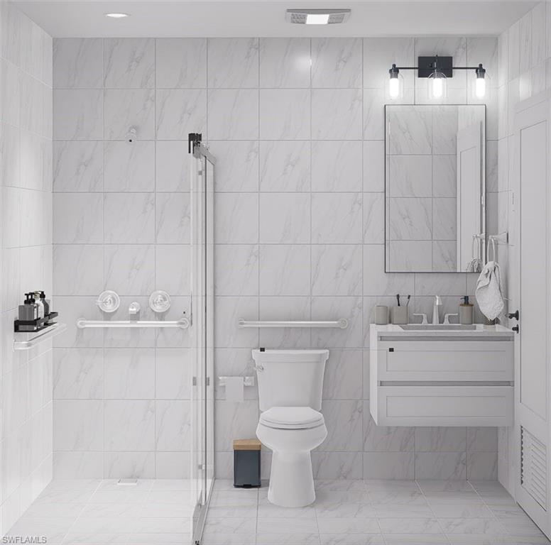 Bathroom featuring tile walls, a stall shower, and vanity