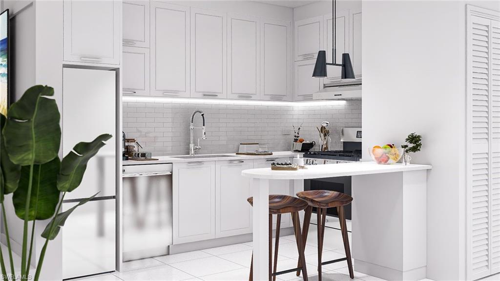 Kitchen with a kitchen bar, white cabinets, tasteful backsplash, and appliances with stainless steel finishes