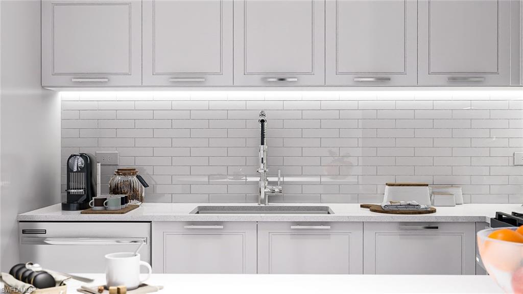 Kitchen with decorative backsplash, light stone countertops, and dishwasher