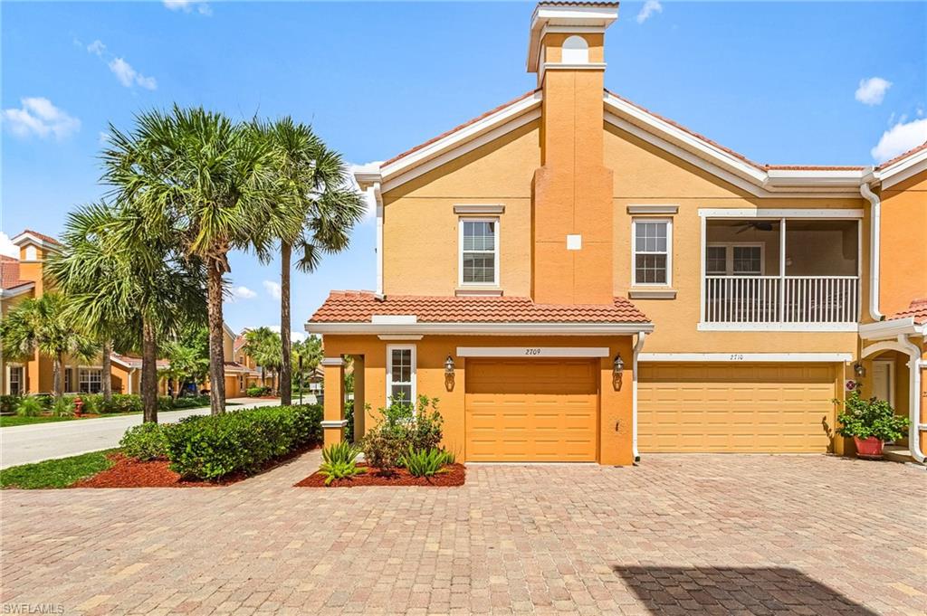 Mediterranean / spanish-style home featuring stucco siding, an attached garage, and decorative driveway