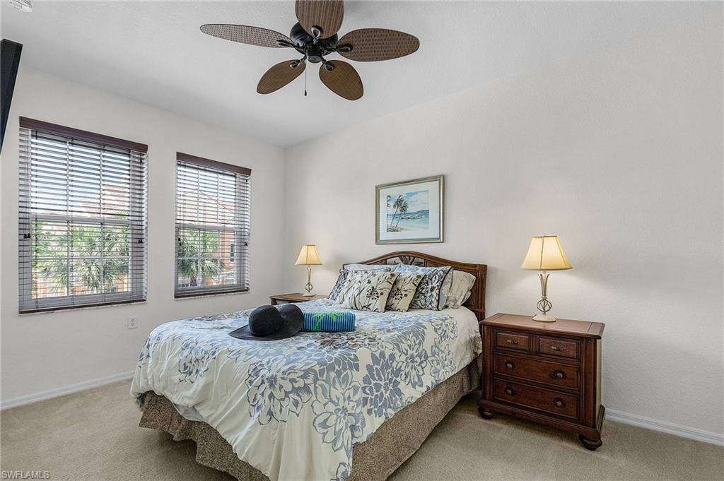 Carpeted bedroom with ceiling fan and baseboards