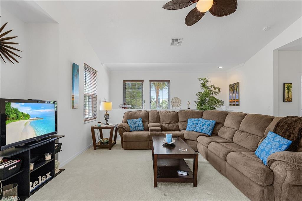 Living area with light carpet, a ceiling fan, and recessed lighting