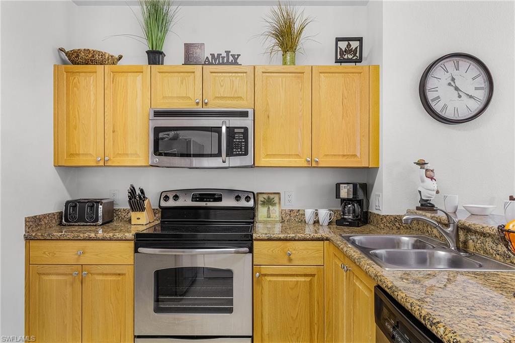 Kitchen featuring stainless steel appliances and light stone counters