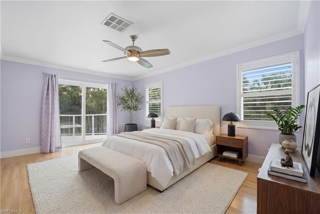 Spacious room featuring wood-finish flooring, a ceiling fan with integrated lighting, and crown molding