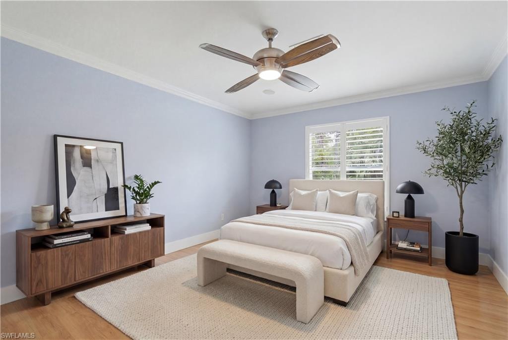 Light blue painted walls featuring a window with white plantation shutters, crown molding, and wood-finish flooring