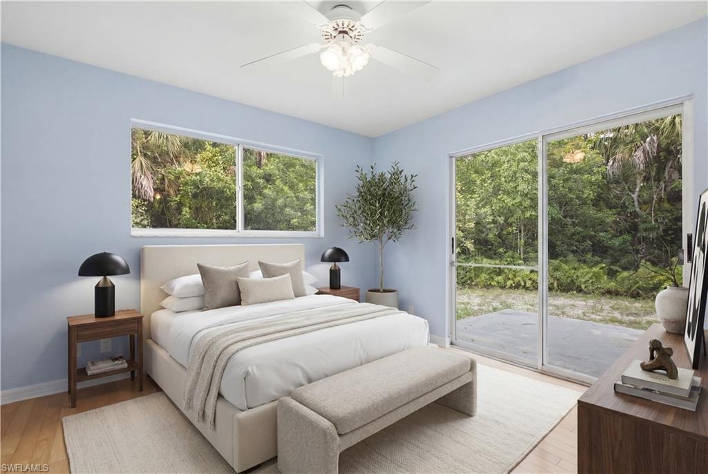 Bedroom featuring wood-finish flooring, a ceiling fan with integrated lighting, and a sliding glass door leading to an outdoor patio